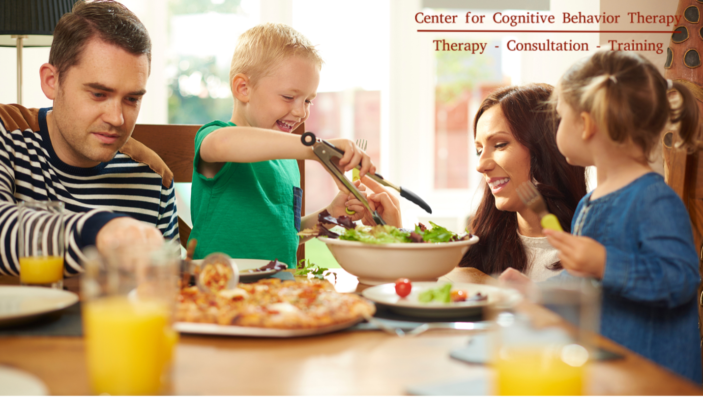 Child enjoying a meal with family after feeding disorder treatment