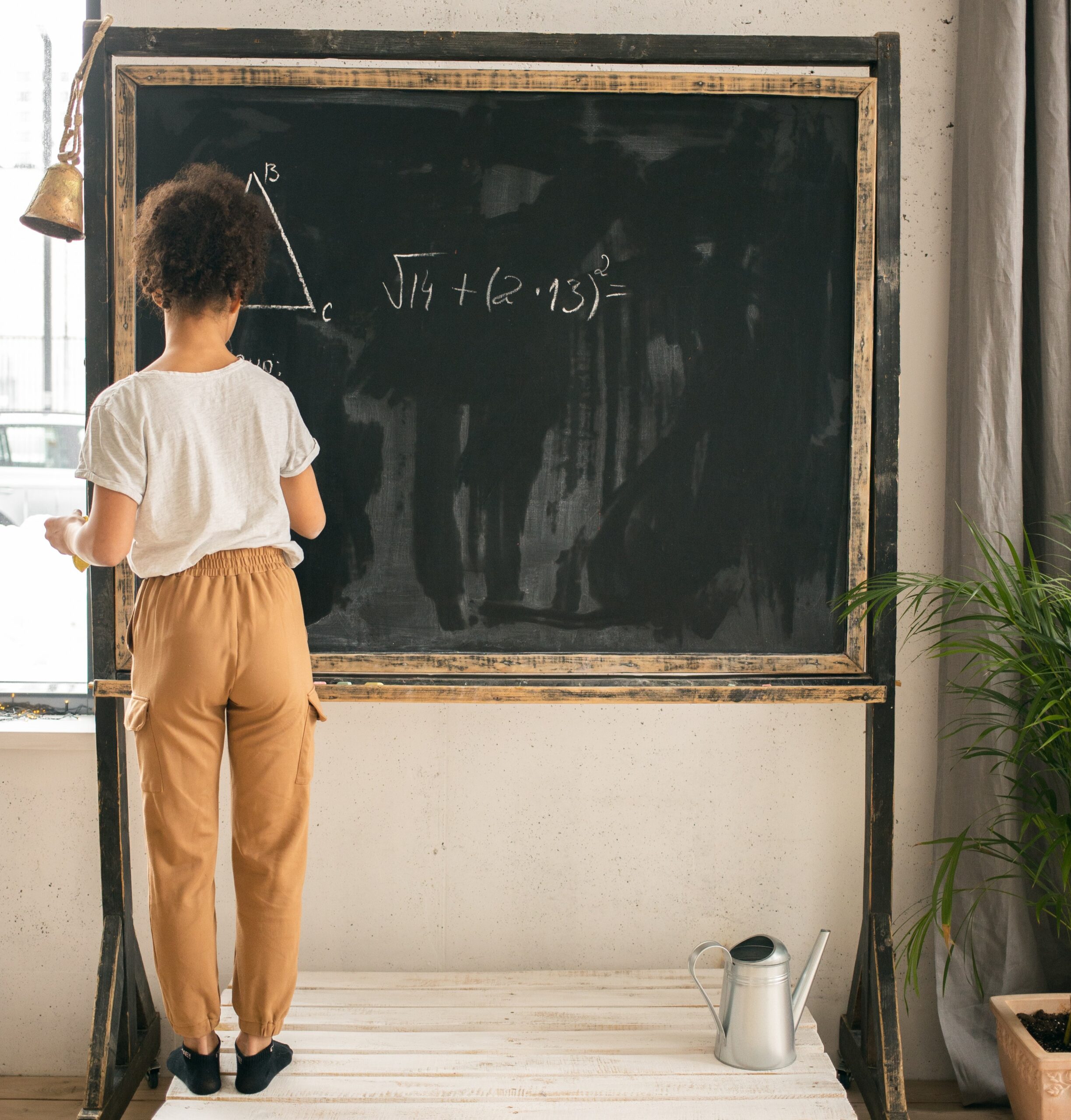Picture of woman doing math problem A child standing in front of a chalkboard doing a math problem